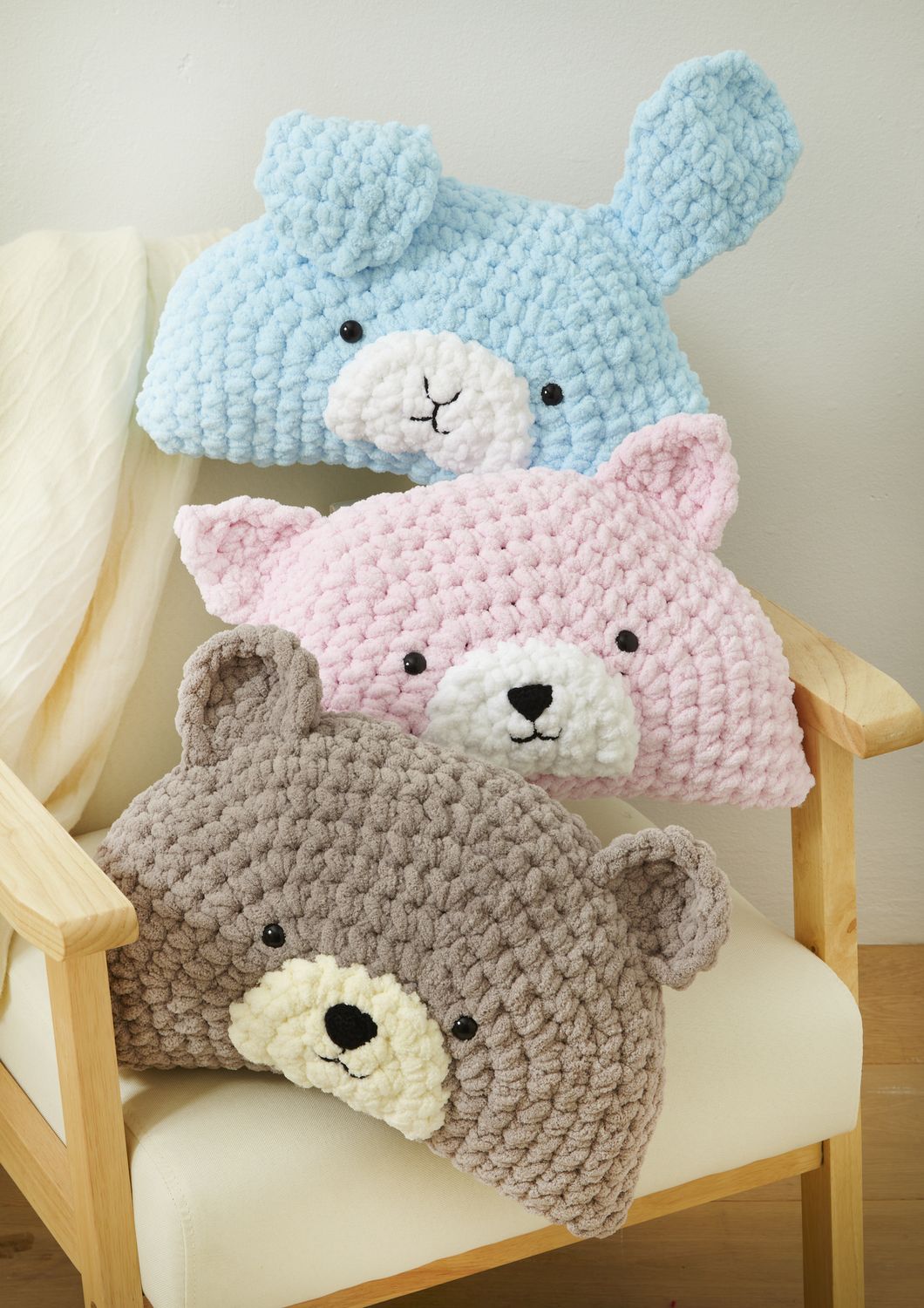 3 crocheted pillows designed to look like animal faces.