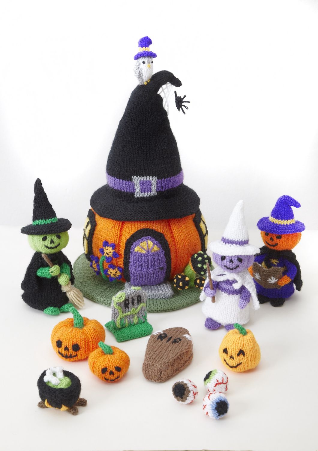 A knitted pumpkin house and multiple Halloween characters, such as a witch, pumpkins and a coffin.