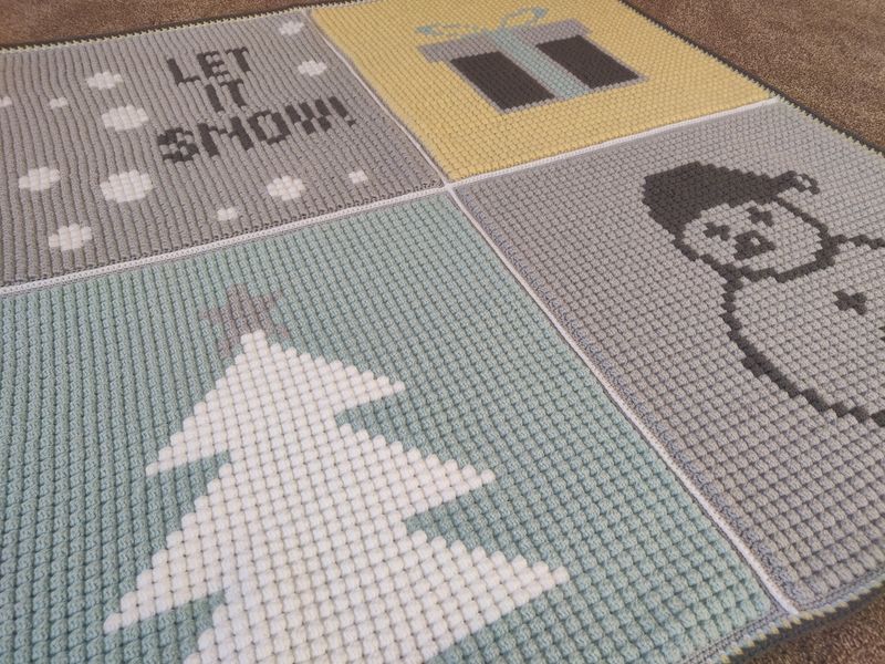 A crocheted bobble stitch blanket with colourwork festive designs.