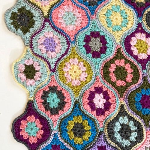 A crocheted blanket made up of lantern shaped motifs in various colours.
