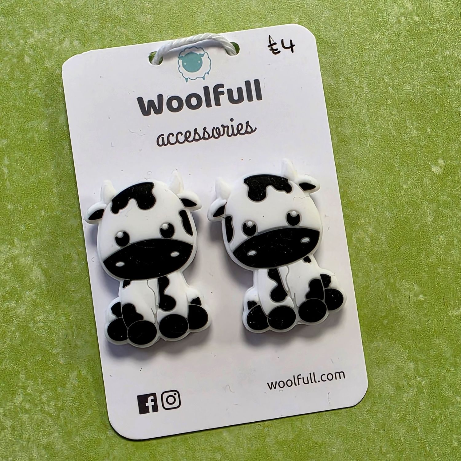 Cartoon cow point protectors mounted on a Woolfull card on a lime green background.