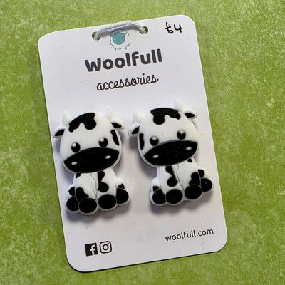 Cartoon cow point protectors mounted on a Woolfull card on a lime green background.