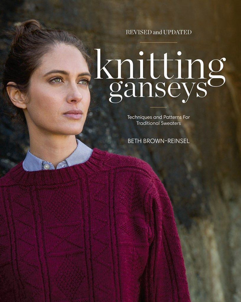 The front cover of the book, showing a burgundy red knitted gansey.