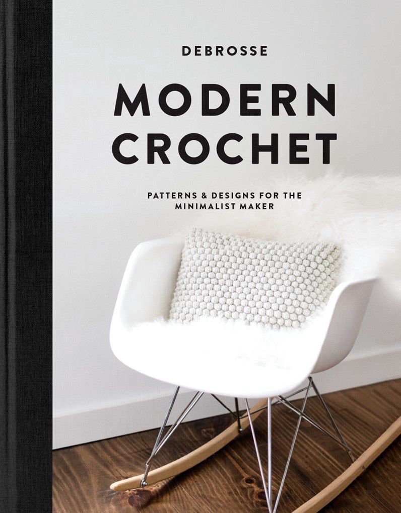 The front cover of the book, showing a crocheted cushion on a chair.