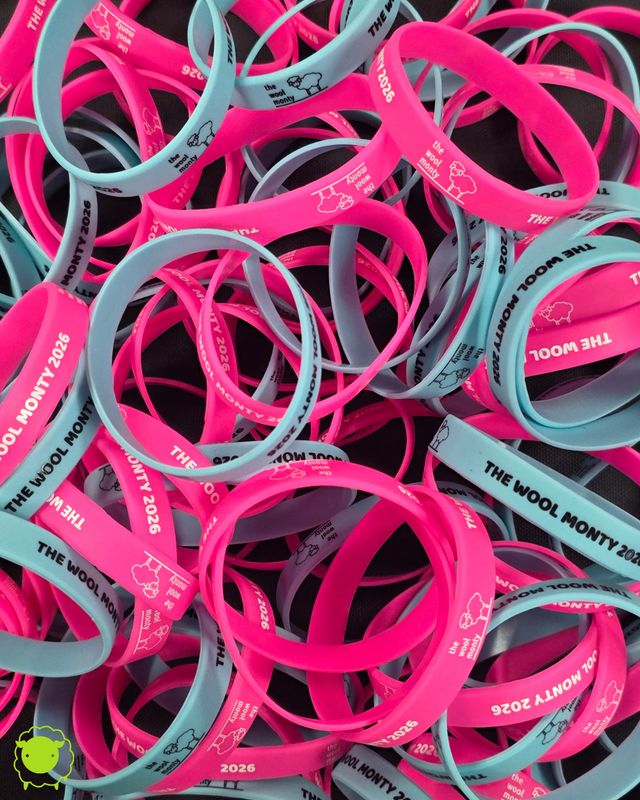 A pile of silicone wristbands, some pink and some blue.