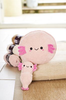 A crocheted axolotl toy and cushion.