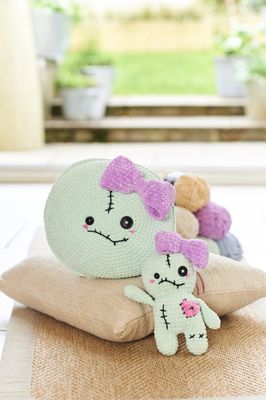 A mint green crocheted voodoo doll and matching cushion.