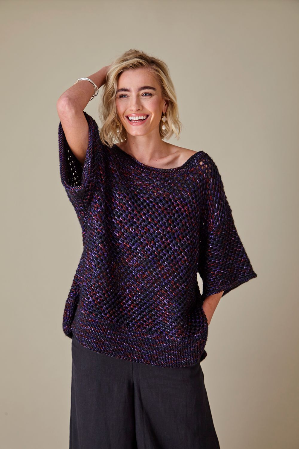 A woman is wearing a dark purple knitted top.