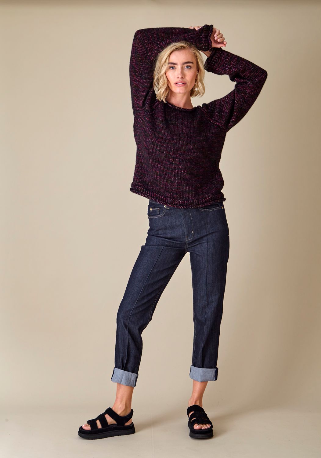 A woman is wearing a dark red knitted sweater.