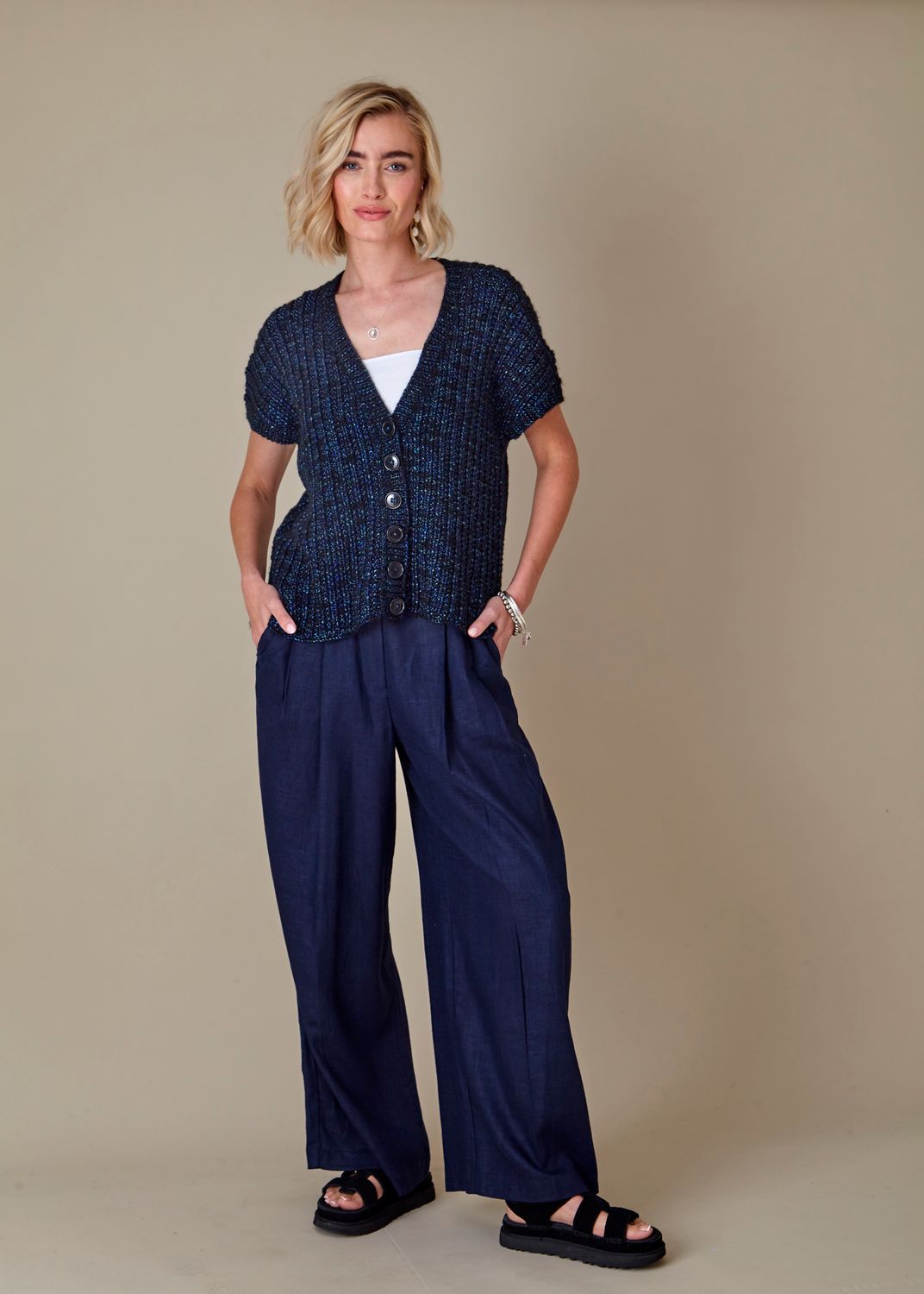 A woman is wearing a dark blue knitted cardigan.