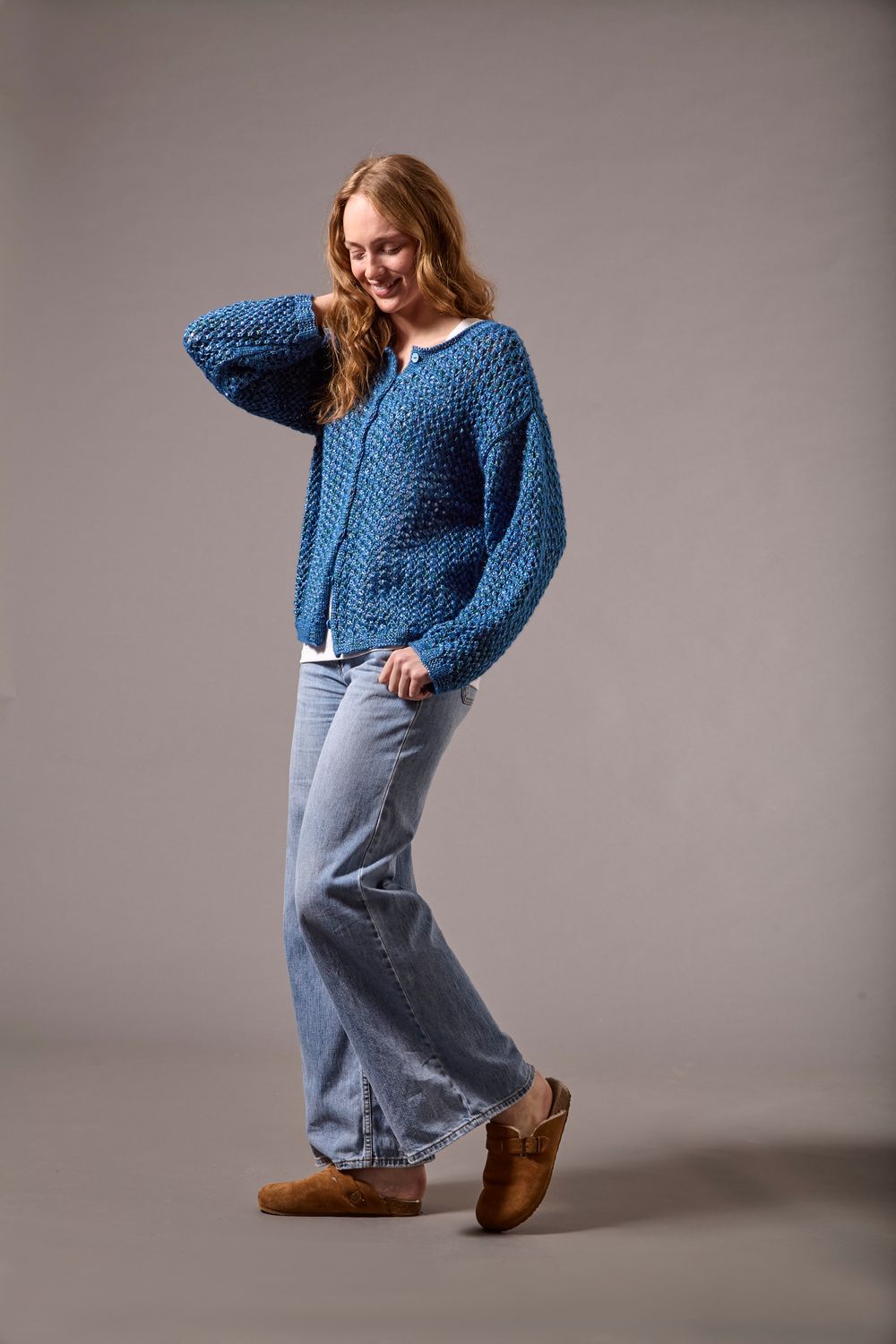 A woman is wearing a dark blue knitted cardigan.
