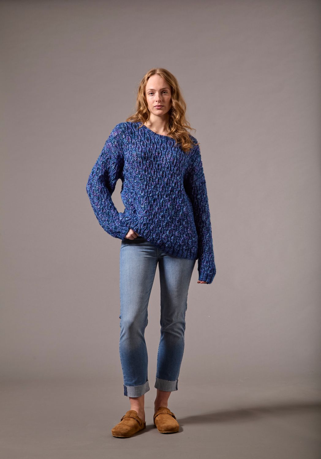 A woman is wearing a dark blue knitted sweater.