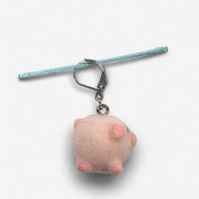 A fuzzy pink pig shaped stitch marker.
