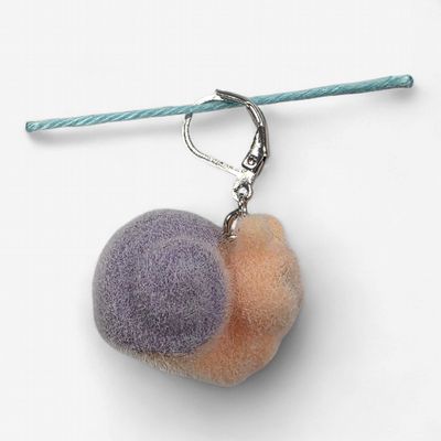 A fuzzy peach and purple snail shaped stitch marker.