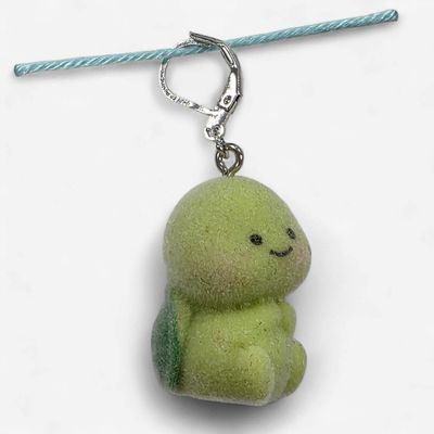 A fuzzy green tortoise shaped stitch marker.