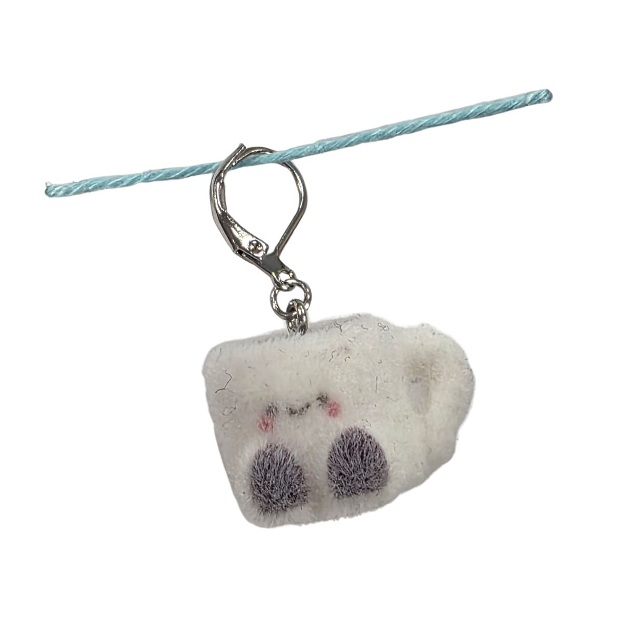 A fuzzy white mug shaped stitch marker.