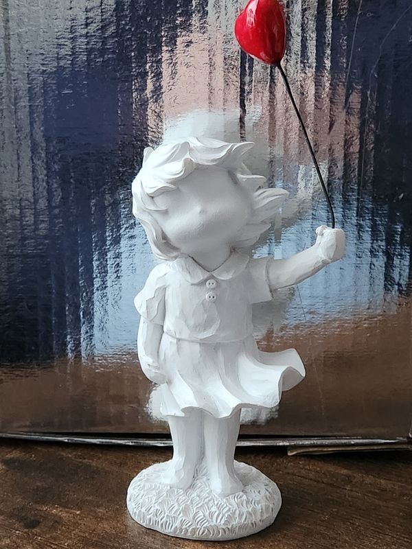 Banksy inspired girl holding a balloon in the wind