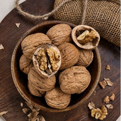 Naturally grown Walnut with textured shells and exposed kernels, showcasing its natural shape and wholesome appeal.