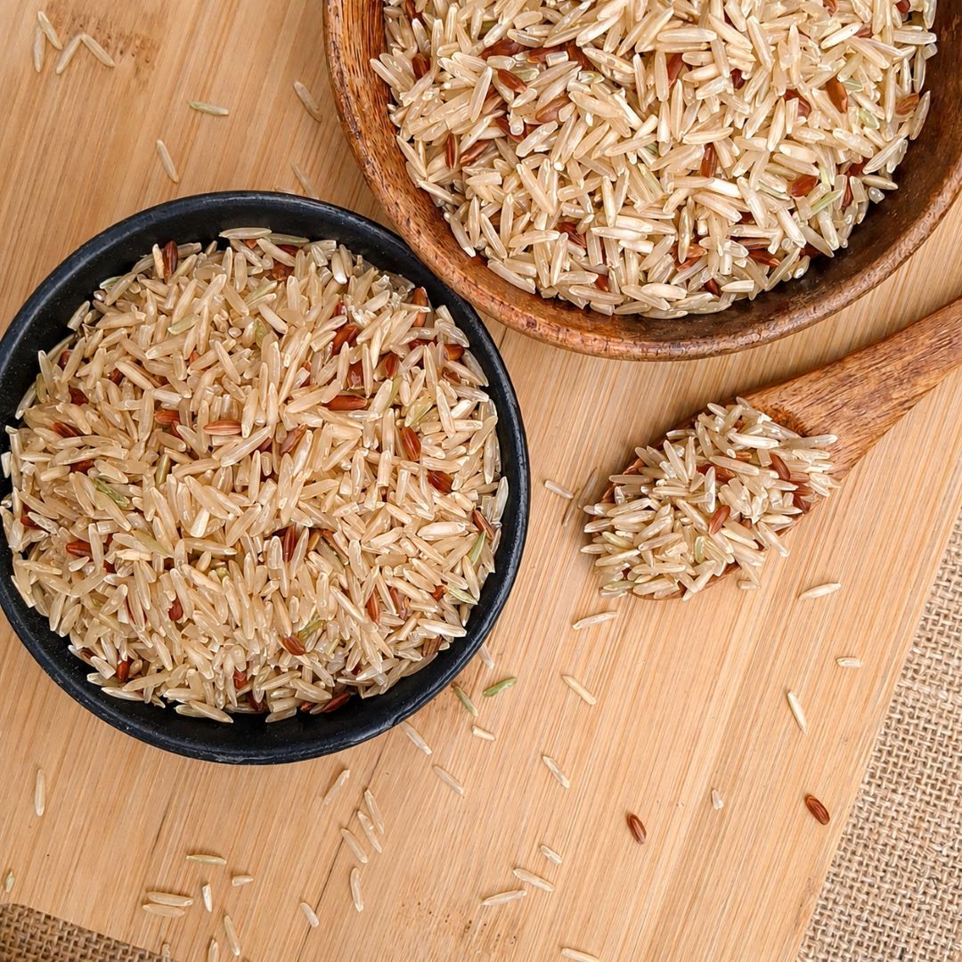Organic Tarawadi Basmati Brown Rice in bowls and a wooden spoon, highlighting earthy grains and naturally varied brown tones.