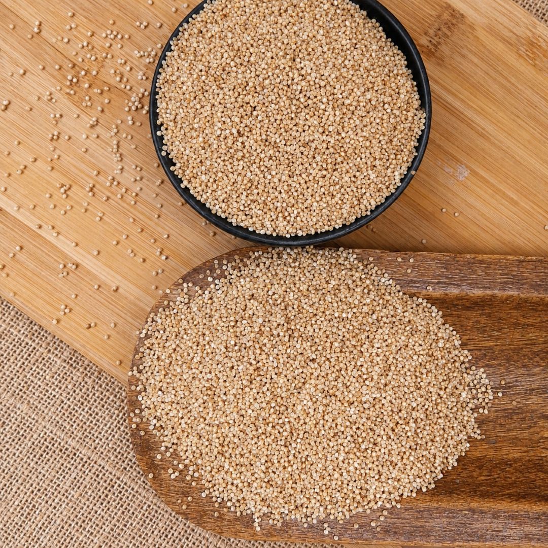 Organic Samak Barnyard Millet grains in bowls and spread on a wooden board, showcasing their tiny, pearly grains and texture.