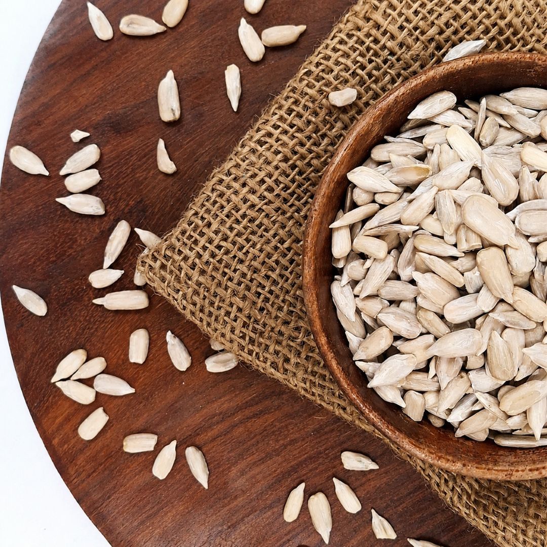 Organic sunflower seeds in a rustic wooden bowl, with creamy texture, ivory colour, vitamin E and healthy fats.