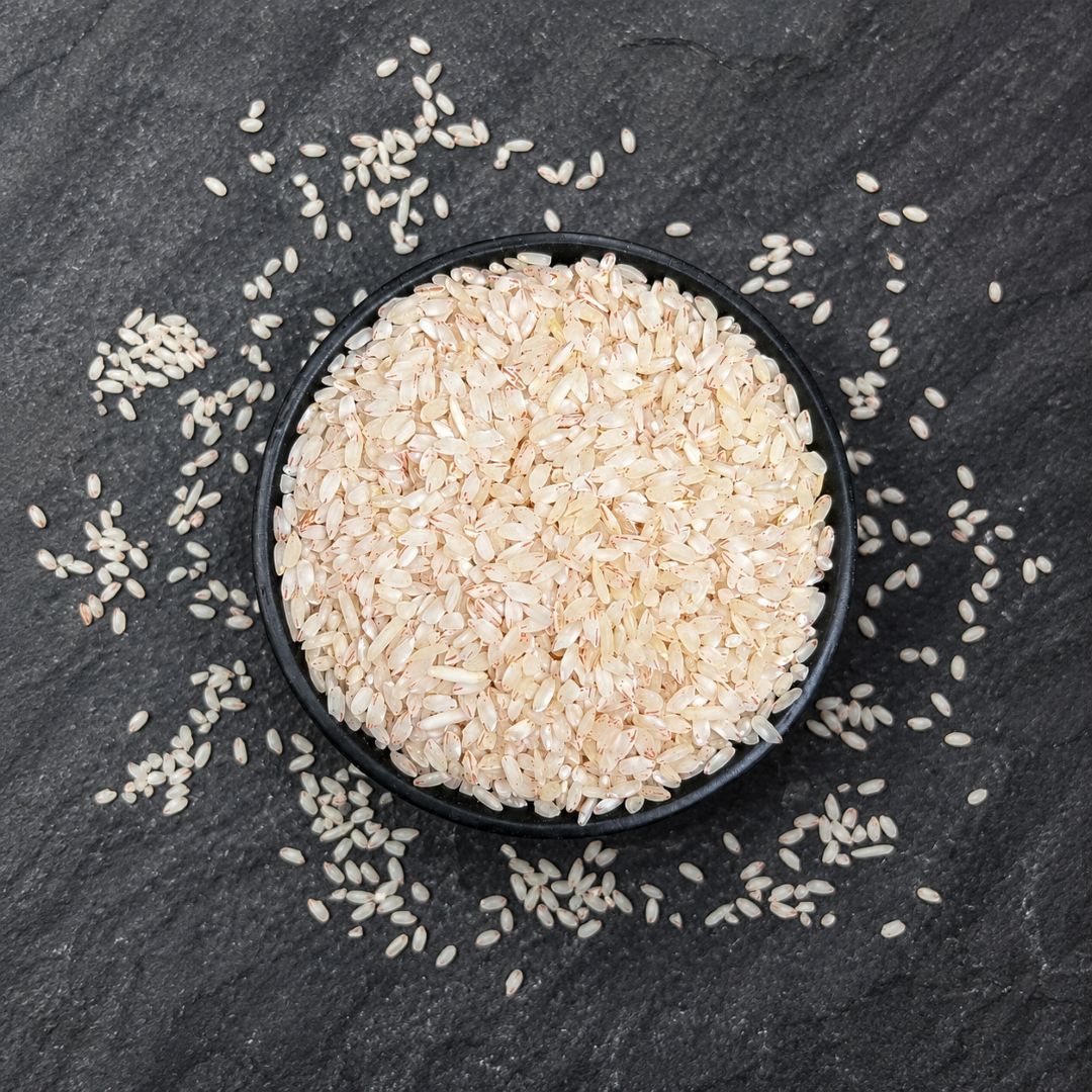 Organic Heritage Red Choba Rice in a bowl, showcasing naturally varied grains with a distinctive reddish hue and appeal.