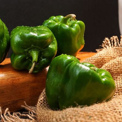 Fresh green Shimla Mirch (Capsicum) with glossy skin and crisp texture, ideal for salads, stir-fries and Indian cooking.