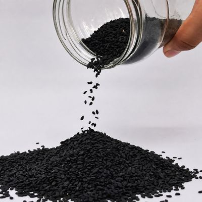 Organic Black Sesame Seeds pouring from a glass jar, highlighting their rich black colour and naturally small, textured seeds