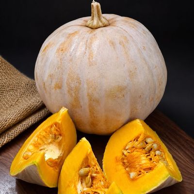 Organic Orange Pumpkin with vibrant orange flesh and seeds, naturally rich in beta-carotene and ideal for Indian cooking.