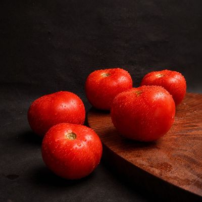Organic Round Tomatoes with vibrant red skin and fresh droplets, naturally rich in lycopene, vitamin C and dietary fibre.