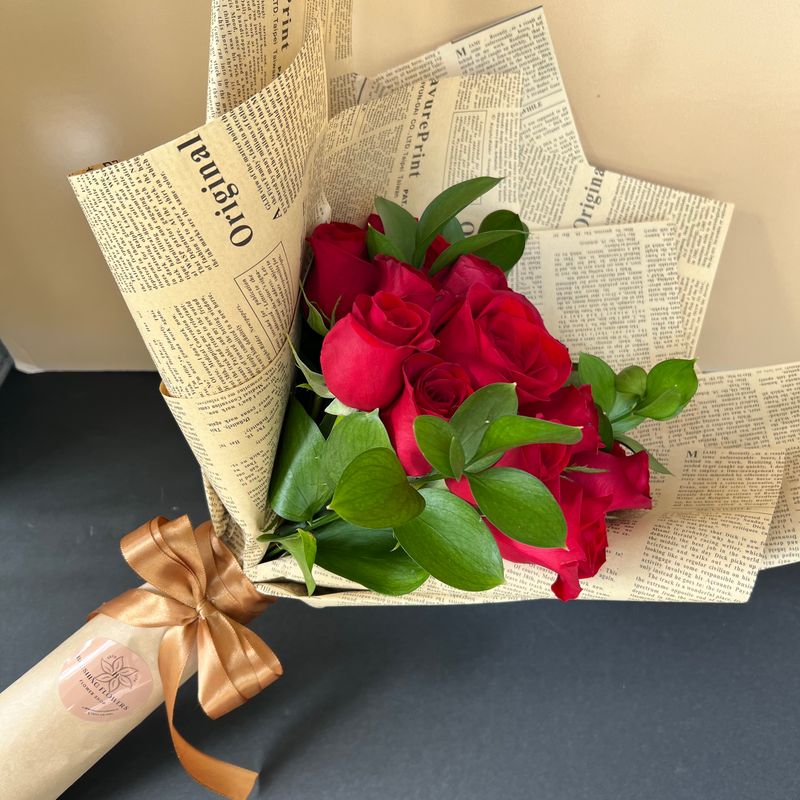 BOUQUET OF RED ROSES WRAPPED IN NEWSPAPER