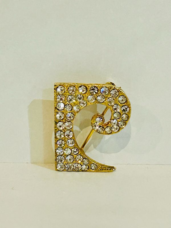Broche de solapa con el monograma de Pierre Cardin en tono dorado con la «P»