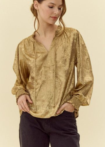 Golden metallic top with frilled tie neck, long peasant sleeves, and smocked cuffs.