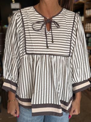 Stripe pattern ¾ sleeve top featuring multicolor band and hem detail