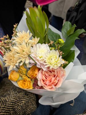 Soft Haze bouquet by Coco Fleur – hand-tied blush and peach blooms in white wrap.