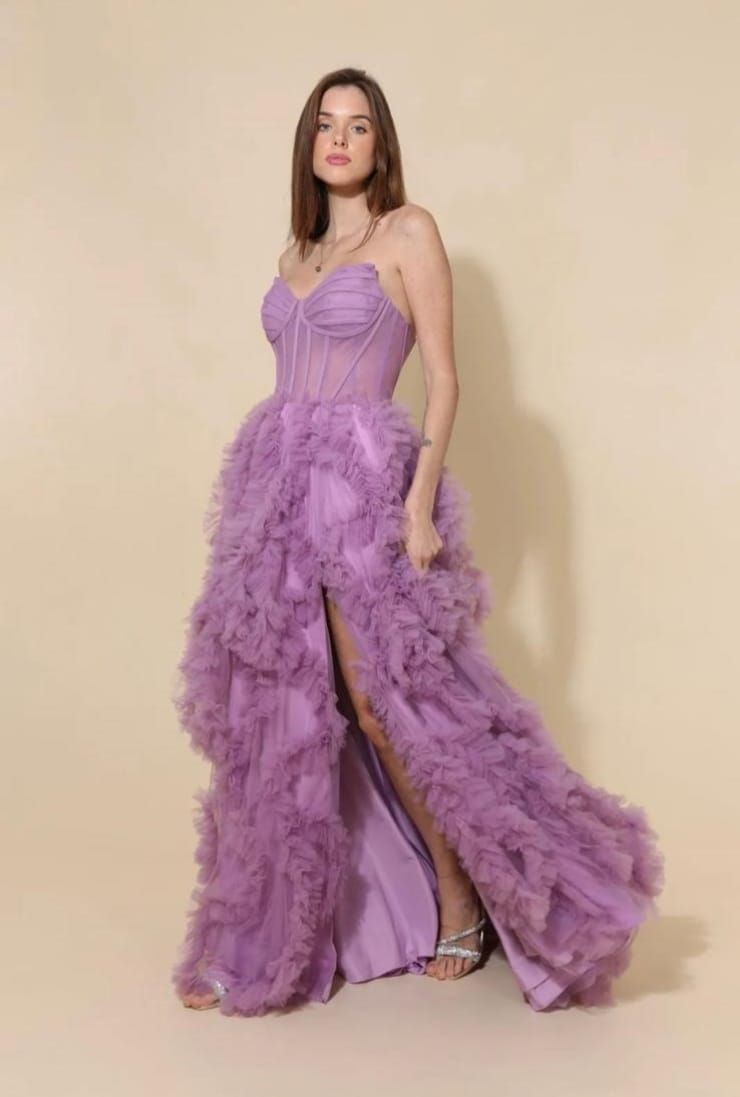 Sublimez vos soirées avec cette robe de soirée bustier lilas , confectionnée en tulle vaporeux avec effet drapé et dotée d&#39;un corset structurant transparent qui affine la silhouette. Sa fente haute dévoile subtilement la jambe pour une allure à la fois sexy et sophistiquée . Parfaite pour un bal, un gala ou un mariage , cette robe longue glamour est le choix idéal pour faire sensation.