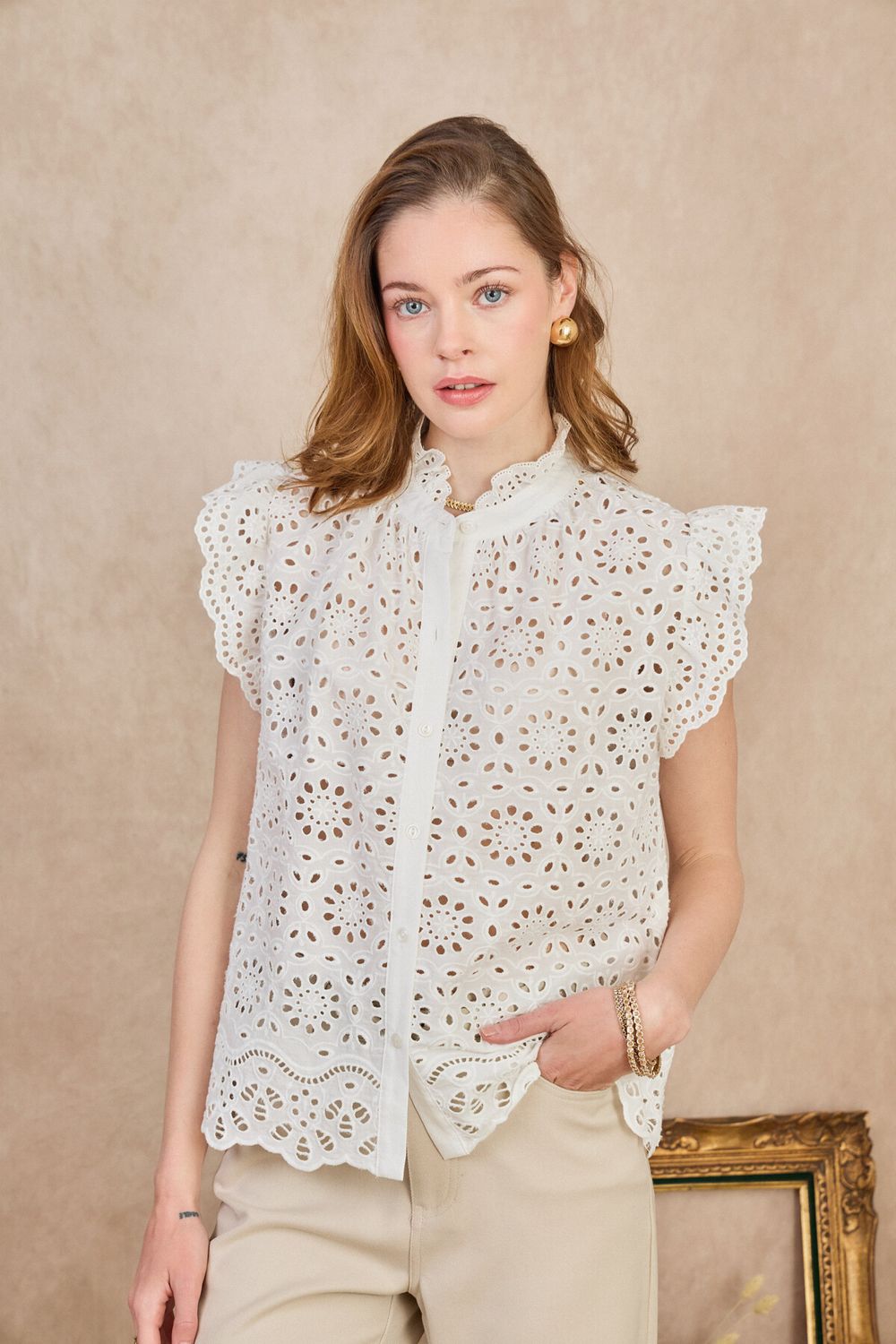 Apportez une touche romantique et élégante à votre tenue avec ce haut femme en dentelle ajourée, sans manches. Son col montant à volants et sa broderie florale délicate en font une pièce idéale pour un look bohème, raffiné et estival.