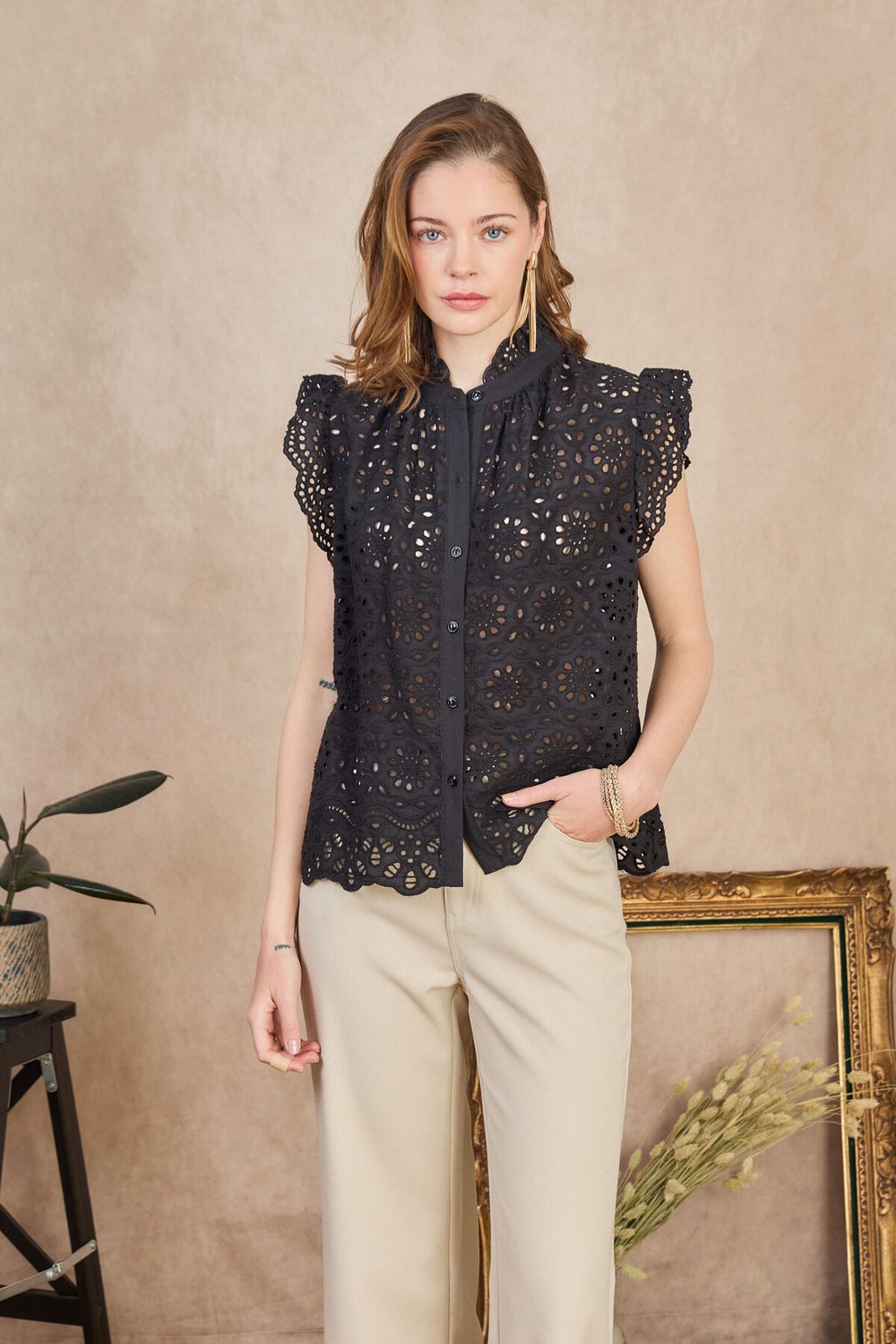 Ce haut noir en broderie anglaise sans manches est un indispensable du dressing féminin. Avec son col montant à volants, ses détails ajourés et sa coupe fluide, il incarne parfaitement le style bohème chic tout en restant élégant et facile à porter au quotidien.
