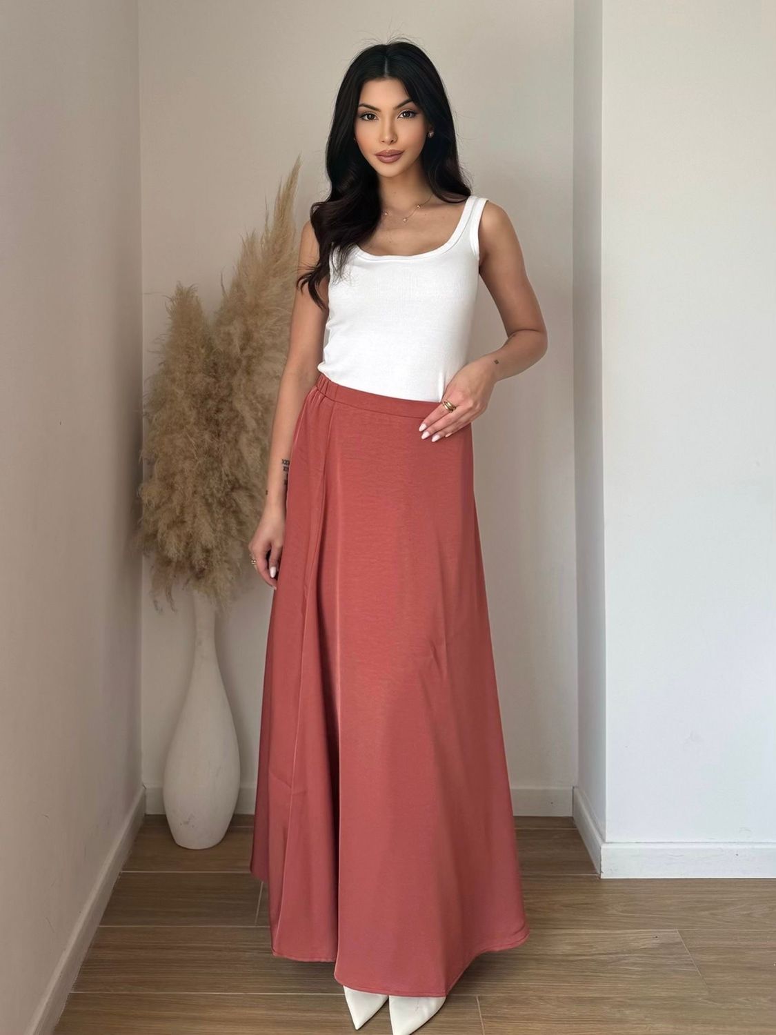 Vue de face : jupe longue terracotta fluide, taille haute, coupe évasée. Look bohème chic femme tendance 2025.