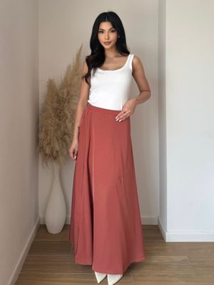 Vue de face : jupe longue terracotta fluide, taille haute, coupe évasée. Look bohème chic femme tendance 2025.