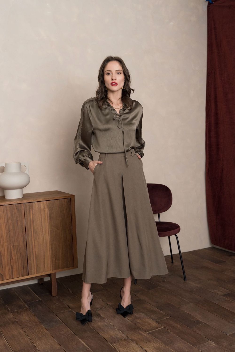 Vue de face : jupe culotte kaki longue à pinces, taille haute avec poches. Look chic et moderne femme tendance 2025.