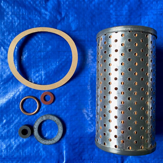 A Peugeot oil filter and seals to suit 203, 403 and 404 placed against a solid blue background. 