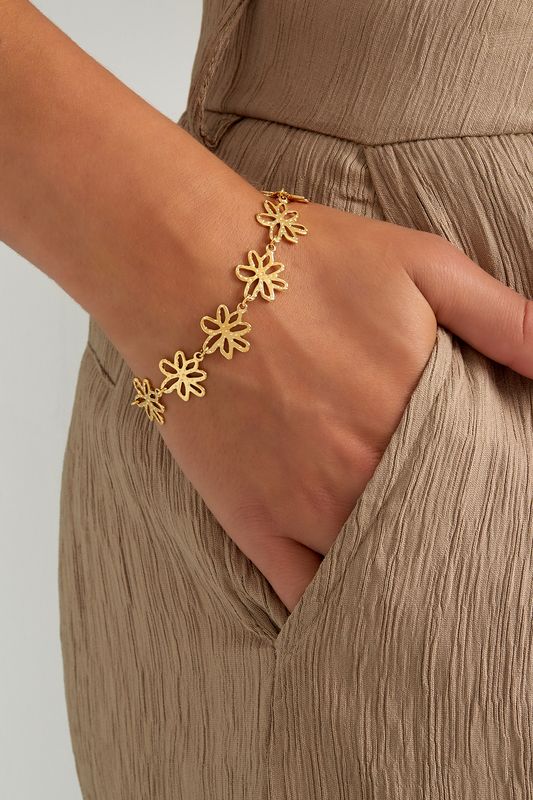 Flower Party Bracelet by Maison Maeva worn on wrist – refined gold-plated stainless steel bracelet with flowers attached to eachother, comfortable and stylish.