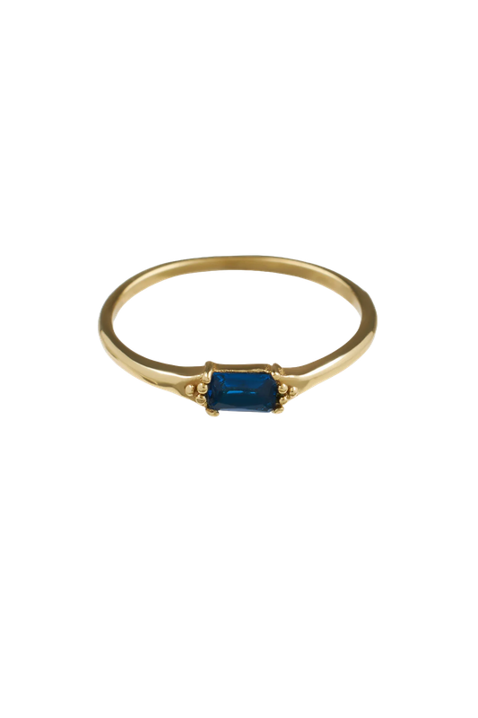 Close-up of the Brass Blue Baguette Ring with a rectangular blue stone, handmade in Bali, offered by Maison Maeva.

