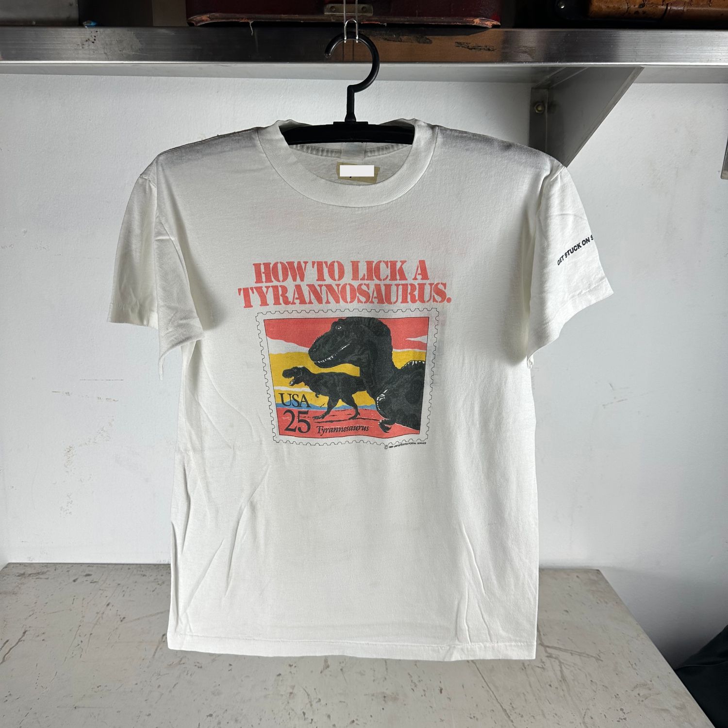 ​​Vintage 1989 How To Lick A Tyrannosaurus USPS Stamp Dinosaur Graphic T-shirt