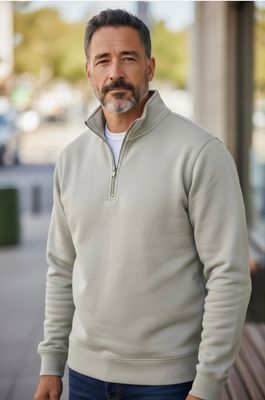 Man outdoors smiling wearing quarter-zipped hoodie
