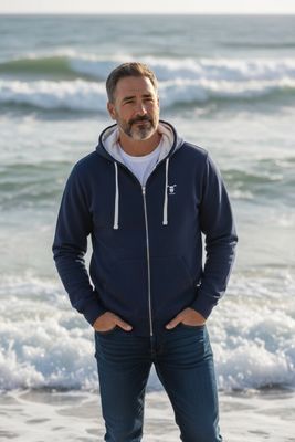 Man wearing Baaad Flockers full-zipped hoodie by the sea