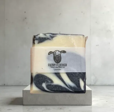 Picture of artisan soap with marble effect on bathroom side, labelled 'Filthy Flocker'