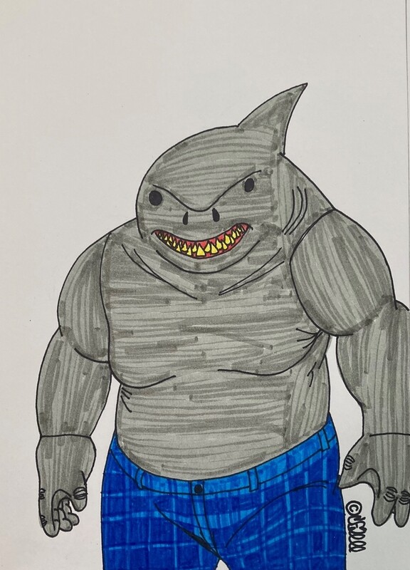 The titular character with the head of a shark and the body of a human stands center frame, looking at the viewer. The King Shark has a shark fin protruding from the top of his head and yellow, pointed teeth. He is wearing dark blue pants, and his skin is colored gray like a shark&#39;s.
