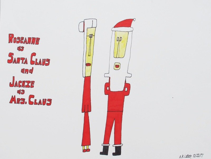 A white haired woman and man are in red clothing. The man is wearing a red Christmas hat, and the woman has a bun &amp; glasses.